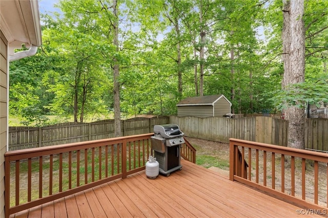 wooden deck with a fenced backyard and grilling area