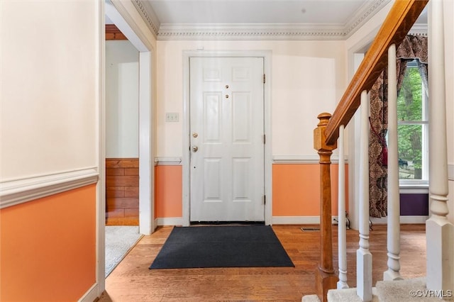 entrance foyer with baseboards, wood finished floors, stairs, and ornamental molding