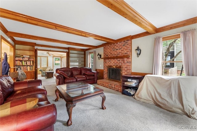 living room with beamed ceiling, carpet flooring, a fireplace, and a ceiling fan