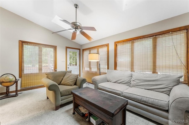 living area featuring vaulted ceiling, ceiling fan, and light colored carpet