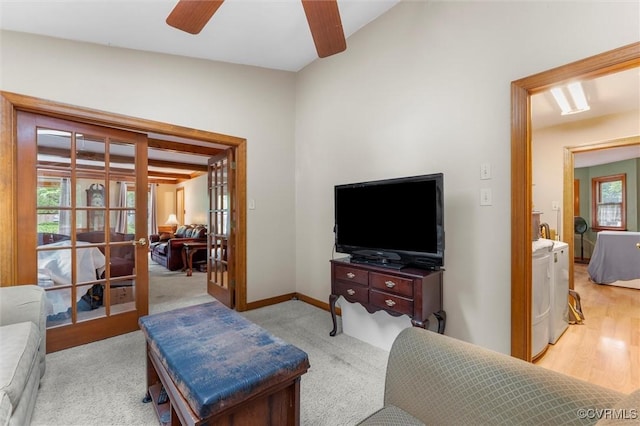 living area with washer and dryer, ceiling fan, french doors, and baseboards