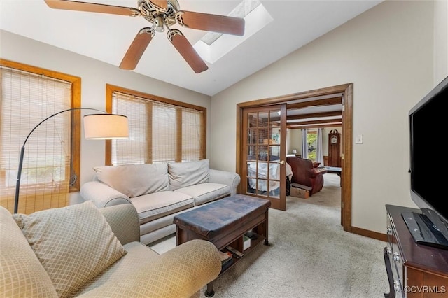 living area with vaulted ceiling, ceiling fan, and light carpet