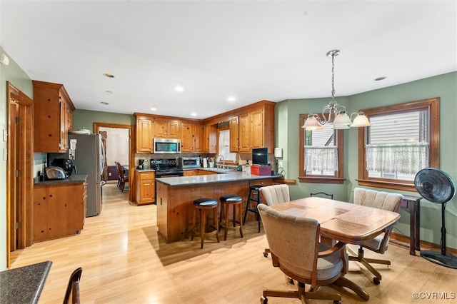 dining area featuring a chandelier, light wood-style floors, and recessed lighting
