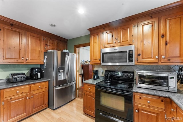 kitchen with stainless steel appliances, brown cabinets, and decorative backsplash
