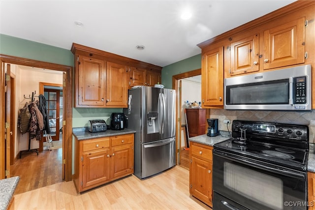 kitchen with appliances with stainless steel finishes, light wood finished floors, brown cabinets, backsplash, and recessed lighting