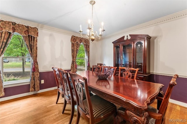 dining area with a chandelier, wood finished floors, baseboards, and ornamental molding
