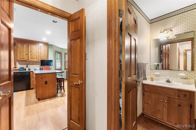 bathroom with wood finished floors, tasteful backsplash, wallpapered walls, vanity, and recessed lighting