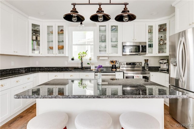 kitchen featuring a sink, white cabinets, a breakfast bar, and stainless steel appliances