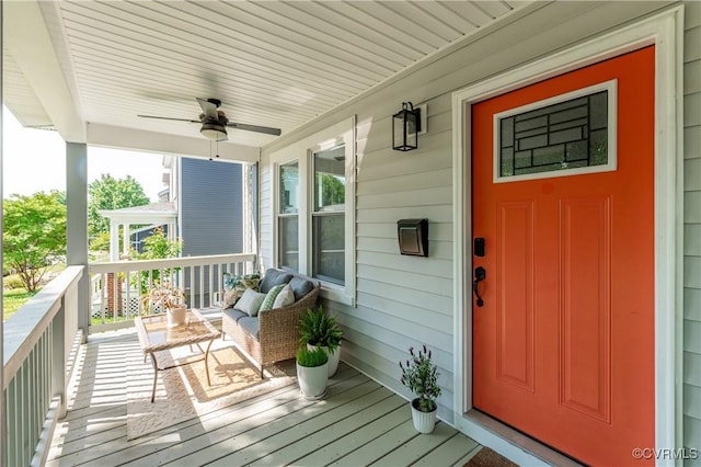 view of exterior entry featuring covered porch and ceiling fan
