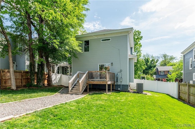rear view of property featuring a fenced backyard, a wooden deck, a lawn, and central AC