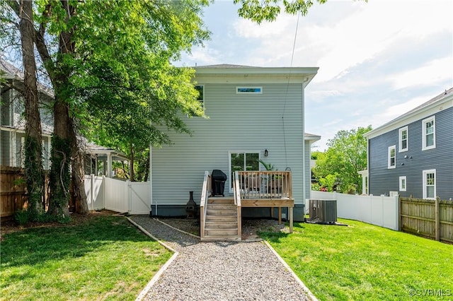 rear view of house with a fenced backyard, central air condition unit, a yard, and a deck
