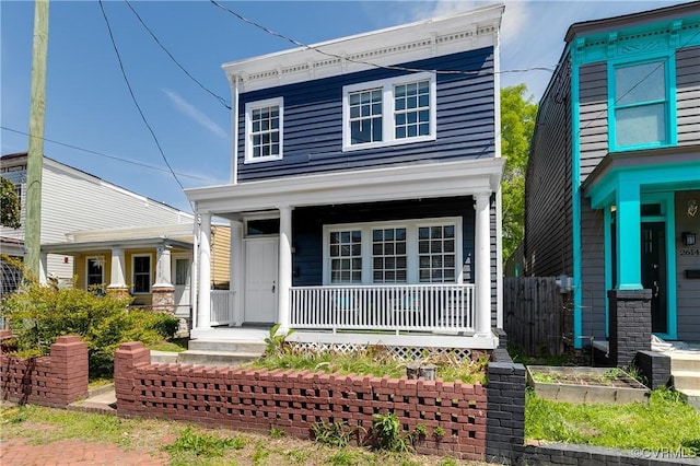 view of front facade with a porch and fence