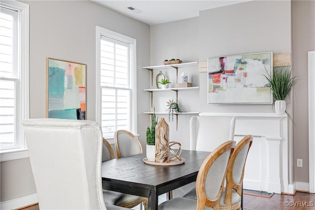 dining room with wood finished floors, visible vents, and baseboards