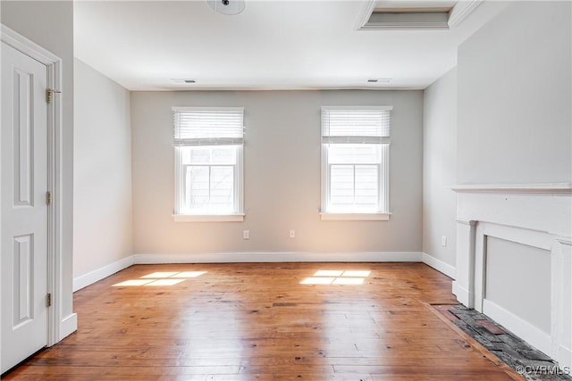 unfurnished living room with baseboards and wood-type flooring