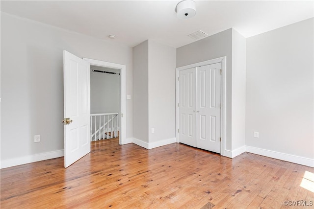 unfurnished bedroom with light wood-type flooring, baseboards, and visible vents