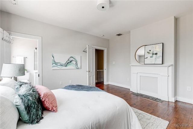 bedroom with wood-type flooring, baseboards, and visible vents