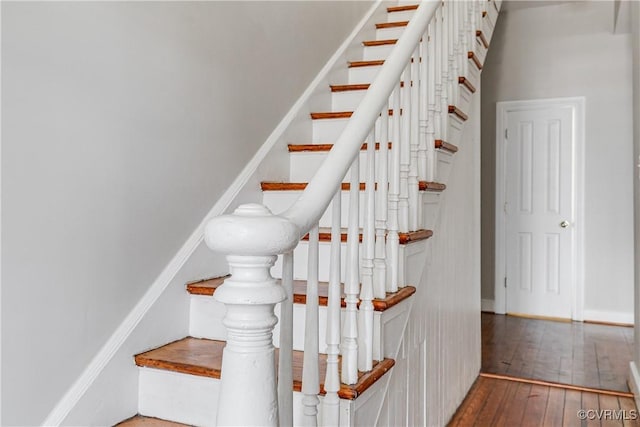 stairway featuring hardwood / wood-style flooring and baseboards
