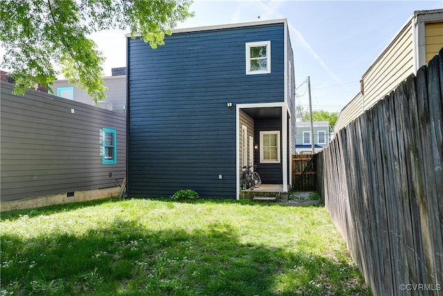 back of property with a yard and fence