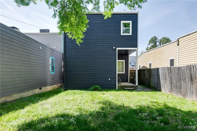 back of property featuring a fenced backyard and a yard