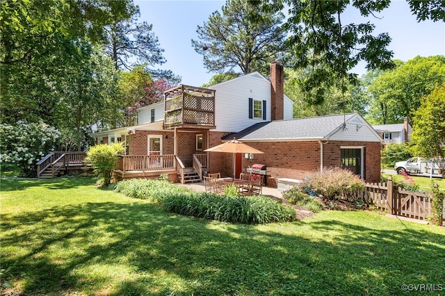 rear view of property featuring a lawn, a wooden deck, a chimney, and brick siding