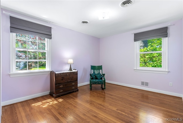 sitting room with visible vents, baseboards, and wood finished floors