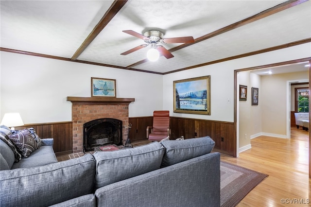 living room featuring a wainscoted wall, ceiling fan, and wood walls