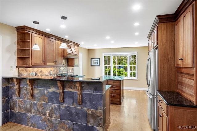 kitchen featuring freestanding refrigerator, a peninsula, open shelves, and light wood finished floors