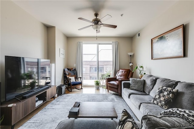 living room with visible vents, a ceiling fan, and light wood finished floors