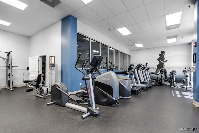 gym with a towering ceiling and a paneled ceiling