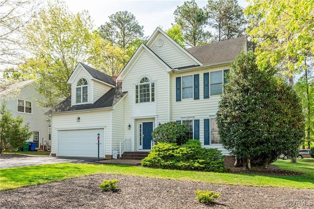 view of front facade with a shingled roof and aphalt driveway
