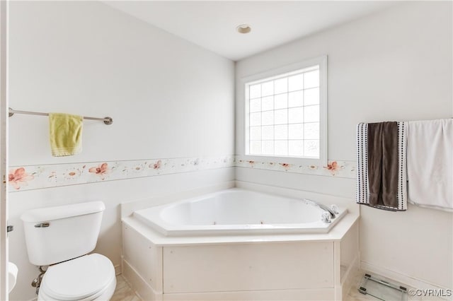 bathroom with a jetted tub and toilet