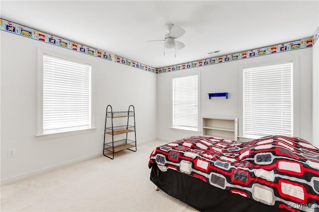 carpeted bedroom featuring visible vents, baseboards, and ceiling fan