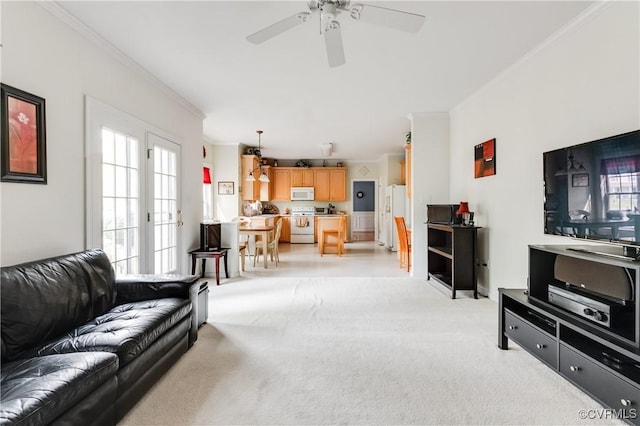 living room featuring crown molding, plenty of natural light, light carpet, and a ceiling fan