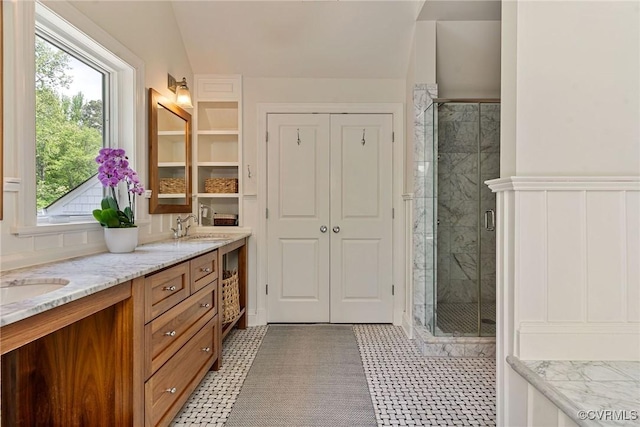 full bathroom with double vanity, a sink, and a shower stall