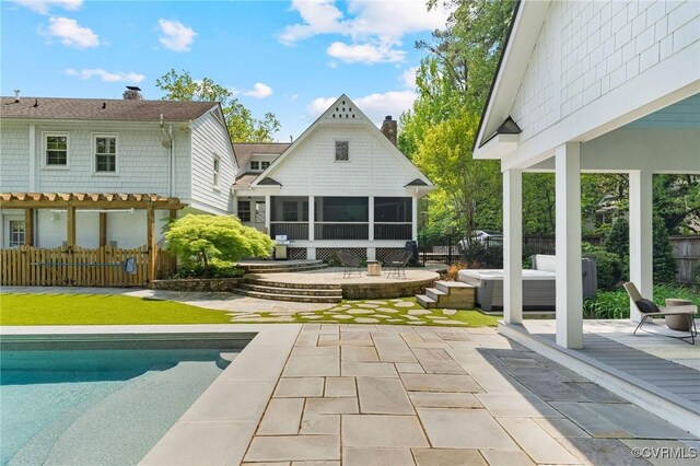 back of house featuring a chimney, an outdoor pool, a sunroom, a patio area, and fence
