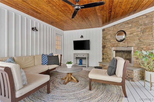 living room featuring ceiling fan, wooden ceiling, wood finished floors, and a fireplace
