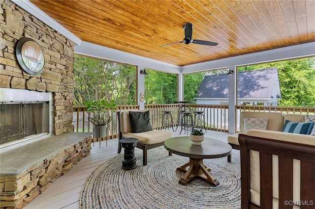 sunroom featuring ceiling fan and an outdoor living space with a fireplace