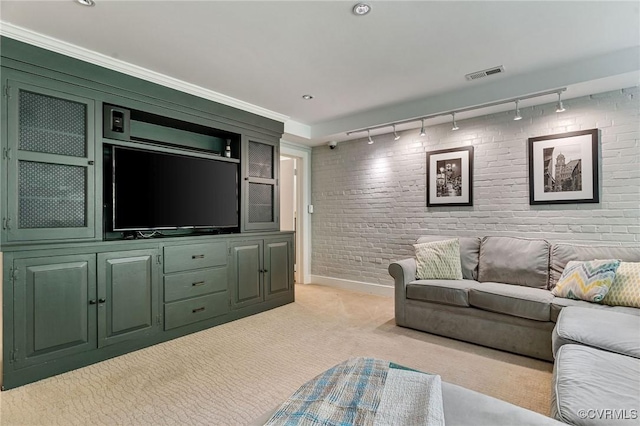 living room with visible vents, rail lighting, brick wall, and light carpet