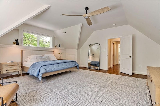 bedroom featuring visible vents, a ceiling fan, wood finished floors, and vaulted ceiling