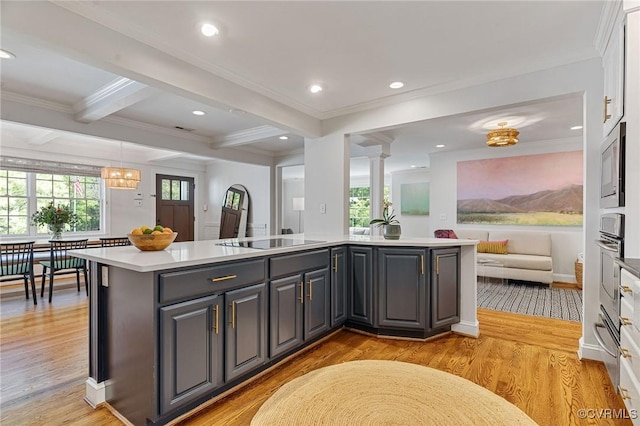 kitchen featuring crown molding, open floor plan, gray cabinets, and stainless steel microwave