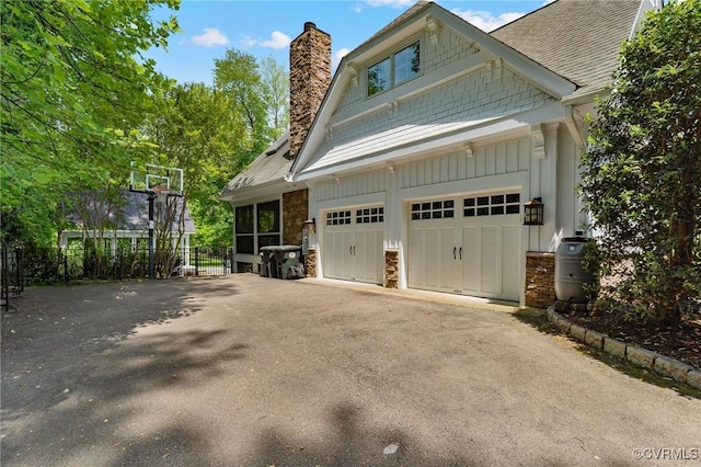 garage with fence and aphalt driveway