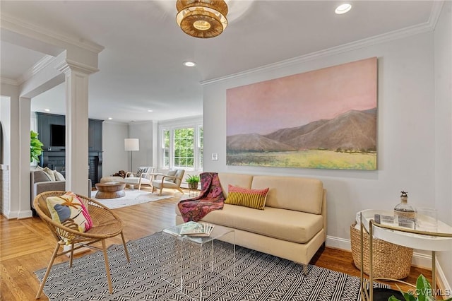 living room with crown molding, a fireplace, recessed lighting, and wood finished floors