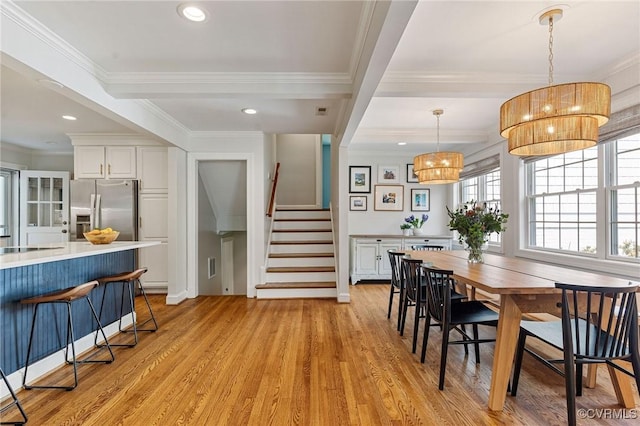 dining room featuring crown molding, light wood-style floors, recessed lighting, beamed ceiling, and stairway