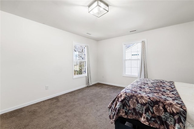 bedroom featuring baseboards, carpet flooring, and visible vents