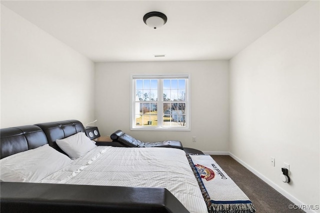 bedroom featuring baseboards and dark colored carpet