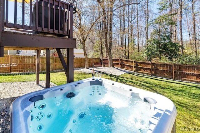 exterior space featuring a fenced backyard, a hot tub, and a lawn