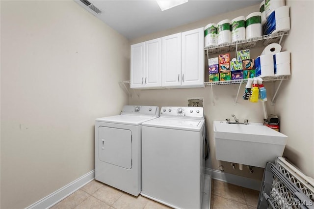 laundry room with cabinet space, baseboards, light tile patterned floors, visible vents, and washing machine and dryer