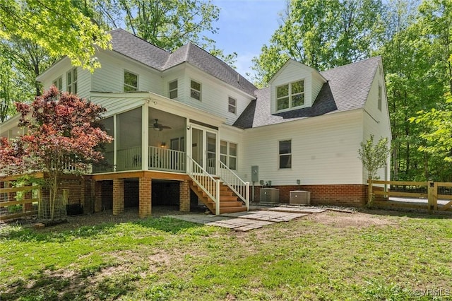 rear view of house featuring a yard, ceiling fan, central AC unit, and a sunroom