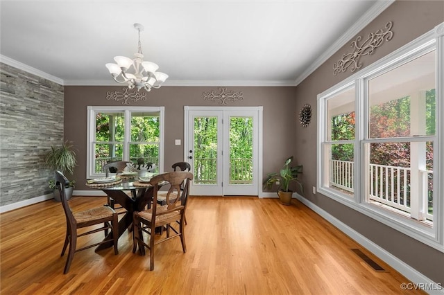 dining room with baseboards, light wood finished floors, a chandelier, and visible vents