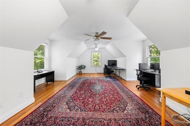 office area featuring baseboards, ceiling fan, wood finished floors, and vaulted ceiling